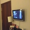 Небольшой телевизор на стене в комнате напротив кровати.