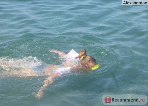 Дочь изучает морское дно на пляже